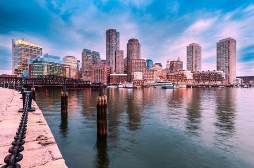 Photo of Boston's Waterfront with seawall and skyscrapers in the background.